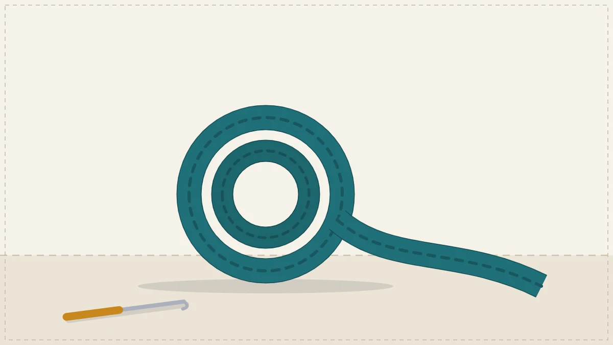A wide flat crocheted bag strap in teal coiled into a loose roll