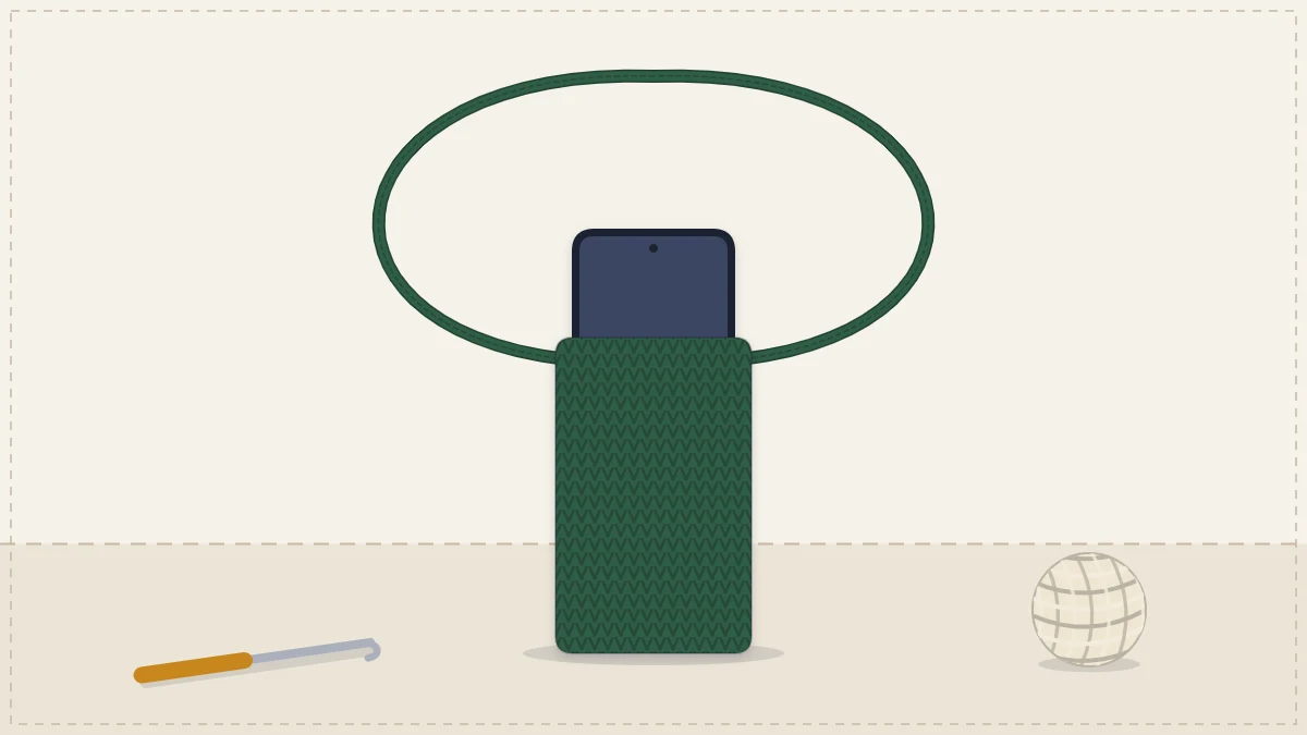 A narrow crocheted crossbody phone pouch with a long cord strap and a phone peeking out of the top