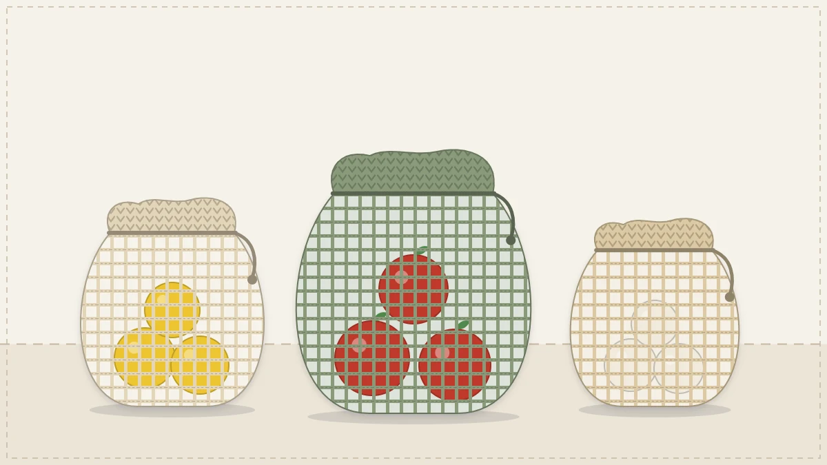 Three small mesh drawstring produce bags holding lemons, apples and garlic